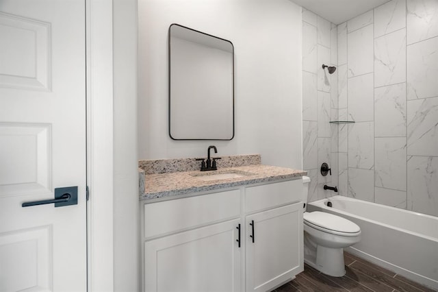 full bathroom featuring wood-type flooring, vanity, toilet, and tiled shower / bath