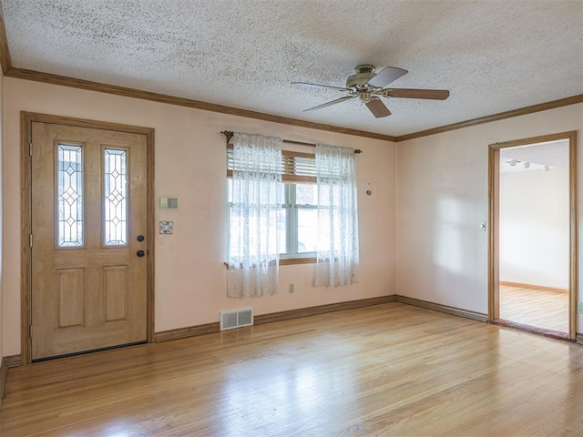 entrance foyer with a textured ceiling, light hardwood / wood-style flooring, ceiling fan, and crown molding