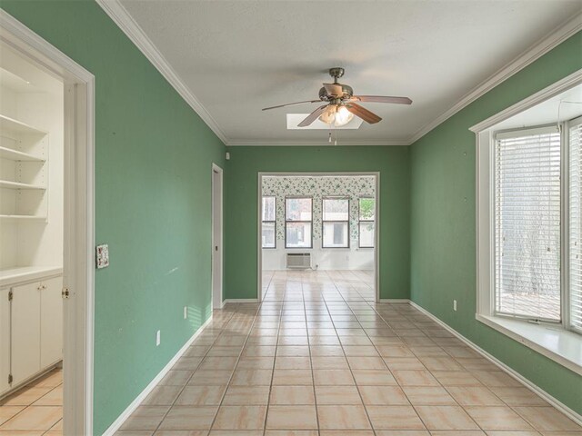 tiled empty room featuring crown molding, ceiling fan, and a healthy amount of sunlight