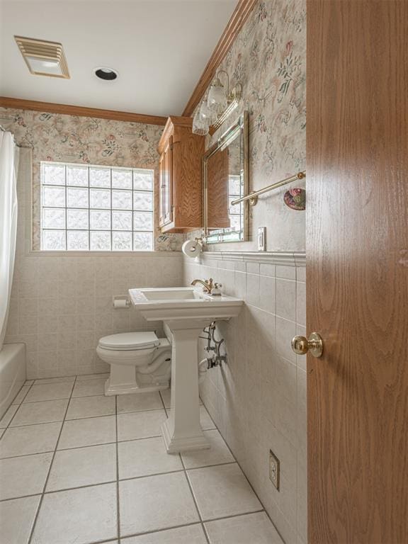 full bathroom featuring toilet, plenty of natural light, tile walls, and tile patterned flooring