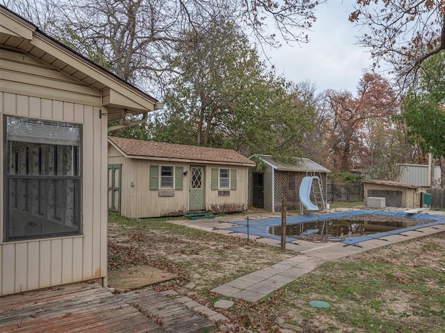 view of swimming pool featuring a storage unit and a water slide