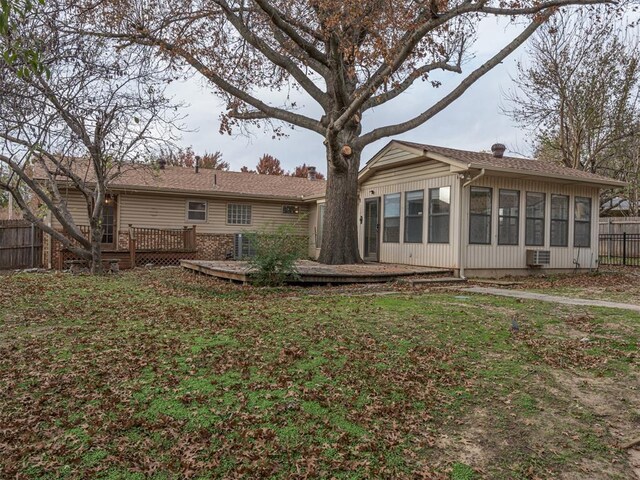 back of house featuring a wooden deck and a sunroom