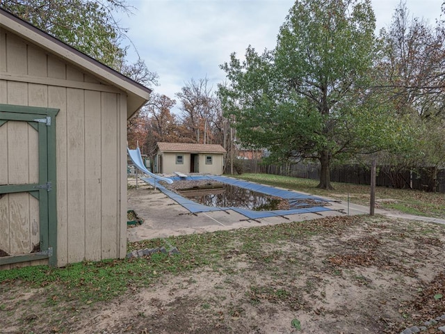 view of pool featuring a storage unit, a patio area, and a water slide