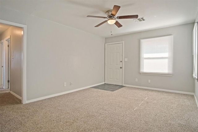 unfurnished room with ceiling fan and carpet