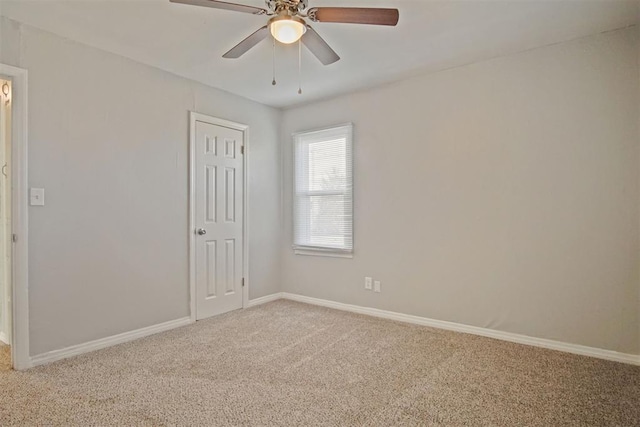 carpeted spare room with ceiling fan