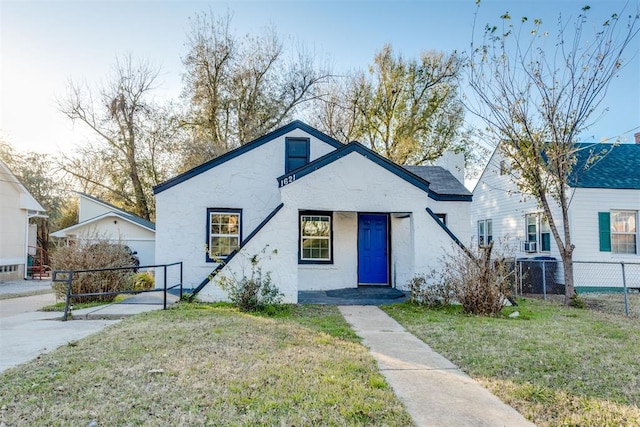 bungalow-style house featuring central AC and a front lawn