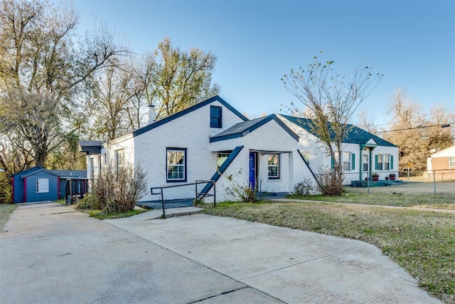 view of front of house featuring an outdoor structure and a front yard