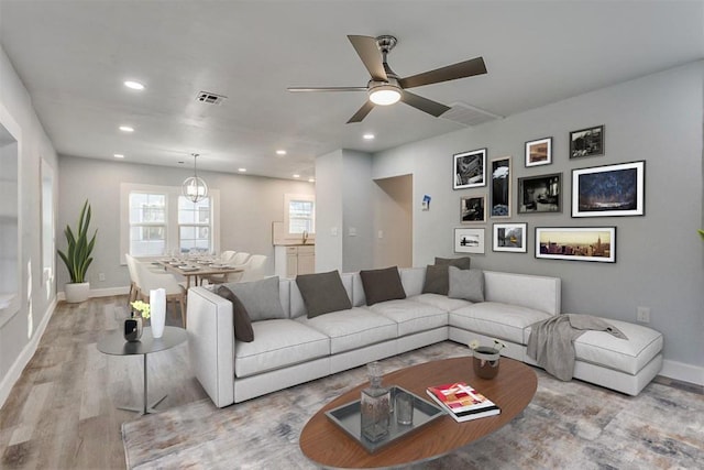 living room with ceiling fan and light hardwood / wood-style floors