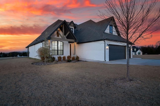 view of front of house featuring a garage and a lawn