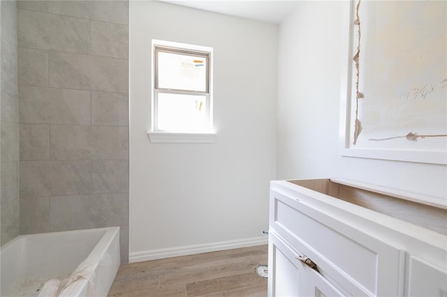 full bathroom featuring baseboards, wood finished floors, and  shower combination