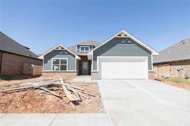 craftsman inspired home with concrete driveway, brick siding, fence, and a garage