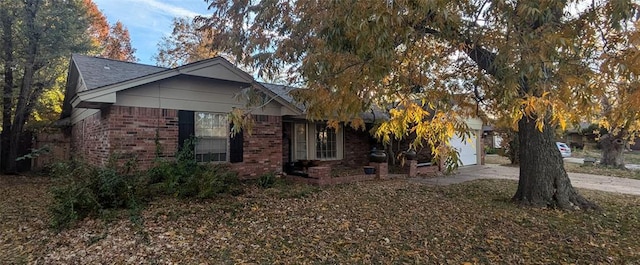 view of side of home with a garage, brick siding, and concrete driveway