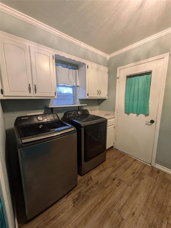 laundry area featuring crown molding, dark hardwood / wood-style flooring, cabinets, and independent washer and dryer