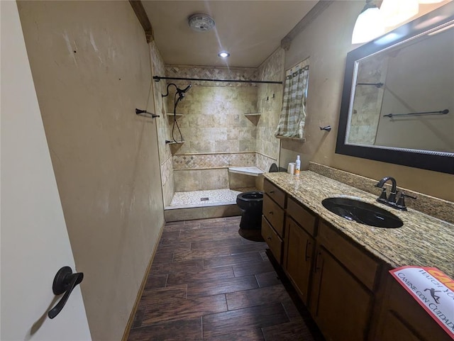 bathroom with vanity, crown molding, tiled shower, hardwood / wood-style flooring, and toilet