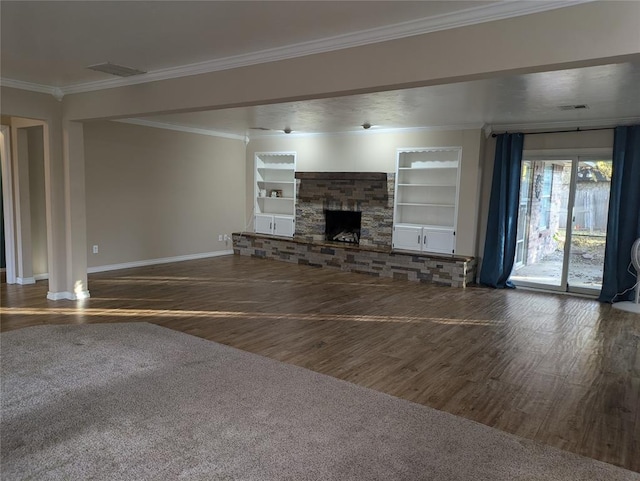 unfurnished living room with built in features, dark wood-type flooring, a stone fireplace, and ornamental molding