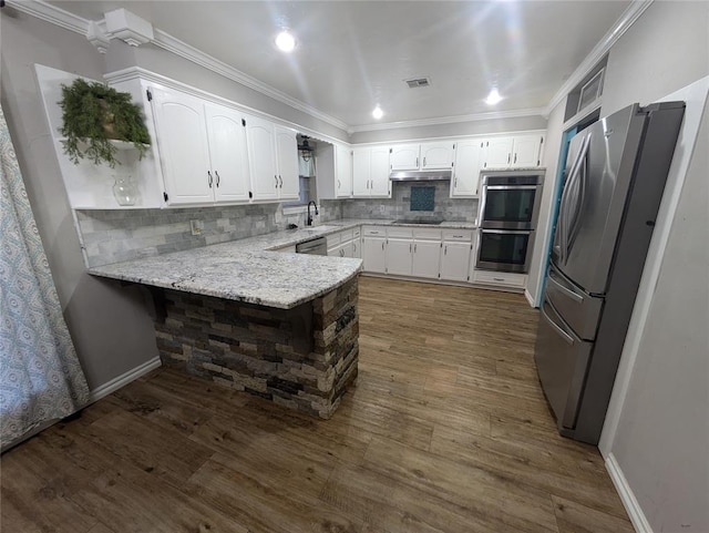 kitchen featuring kitchen peninsula, appliances with stainless steel finishes, dark hardwood / wood-style floors, and white cabinets