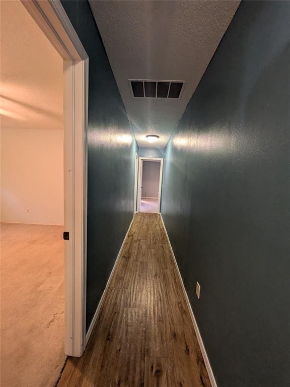 hall featuring wood-type flooring and vaulted ceiling