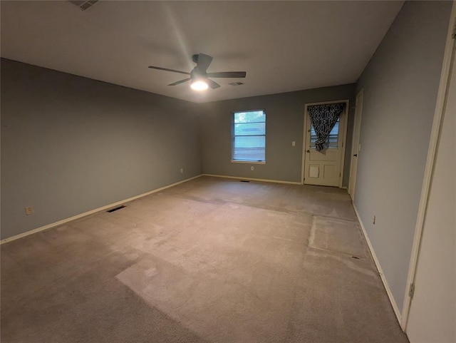 empty room featuring ceiling fan and light colored carpet