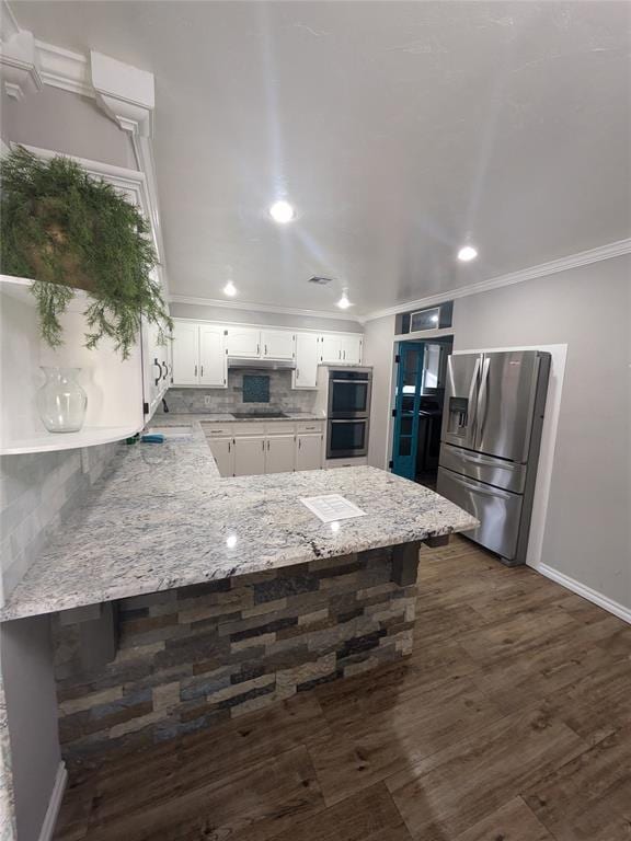 kitchen featuring white cabinetry, dark hardwood / wood-style flooring, backsplash, kitchen peninsula, and appliances with stainless steel finishes