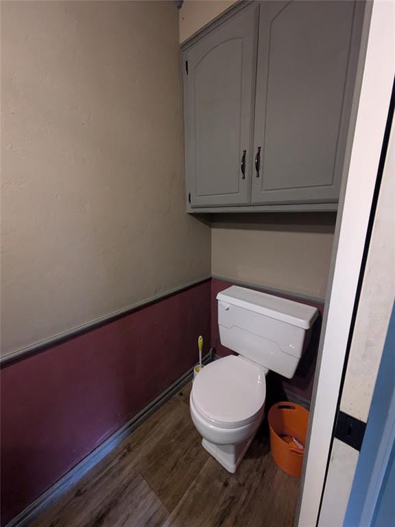 bathroom with hardwood / wood-style floors and toilet