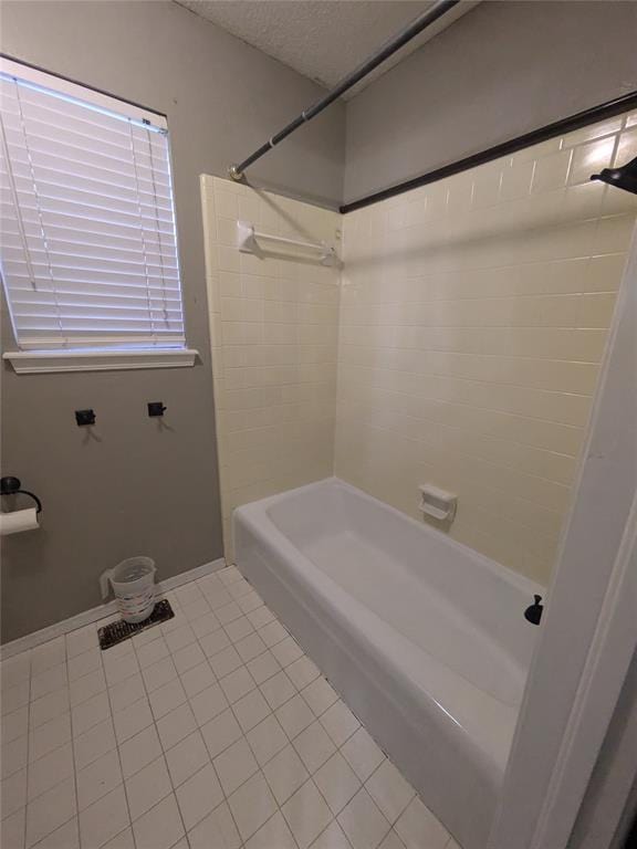 bathroom with tile patterned flooring, a textured ceiling, and washtub / shower combination