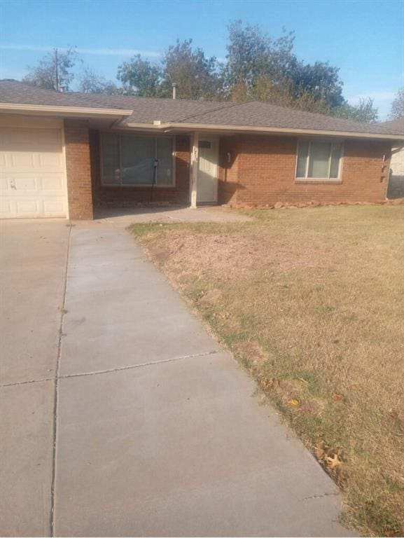 single story home featuring a front lawn and a garage