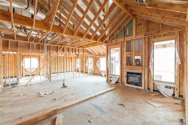 misc room with a glass covered fireplace and lofted ceiling