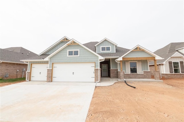 craftsman-style home with concrete driveway, brick siding, board and batten siding, and a garage