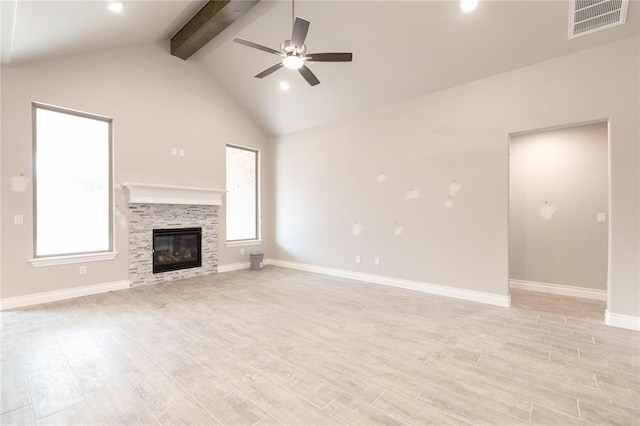 unfurnished living room featuring visible vents, beam ceiling, a fireplace, light wood-style floors, and a ceiling fan