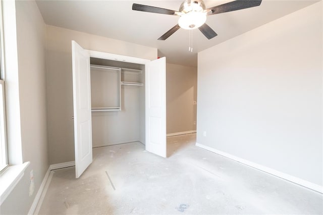 unfurnished bedroom featuring a ceiling fan, baseboards, unfinished concrete floors, and a closet