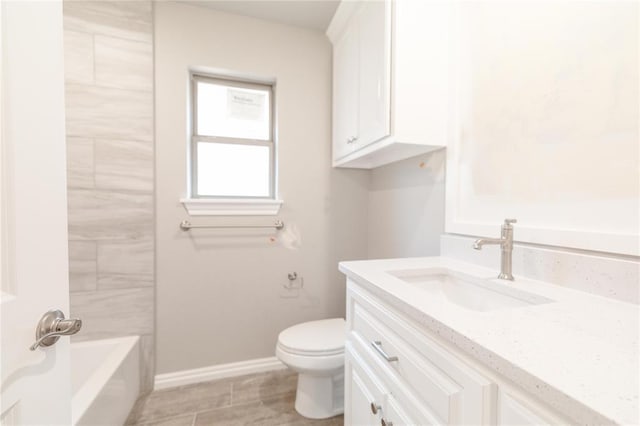 bathroom with vanity, baseboards, and toilet