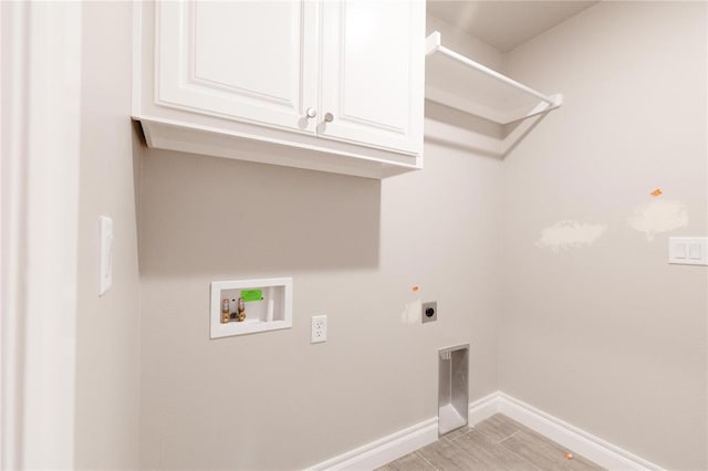 washroom with cabinet space, hookup for an electric dryer, baseboards, and hookup for a washing machine