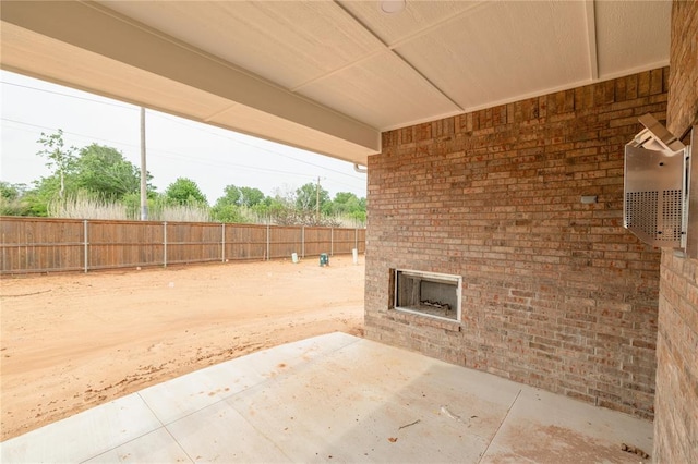 view of patio / terrace featuring a fenced backyard and an outdoor brick fireplace