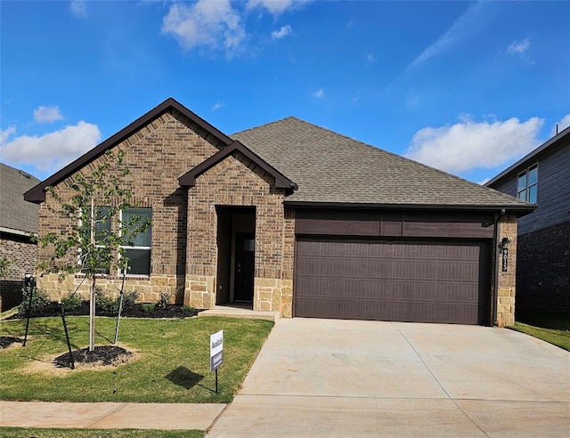 view of front of property featuring a front lawn and a garage