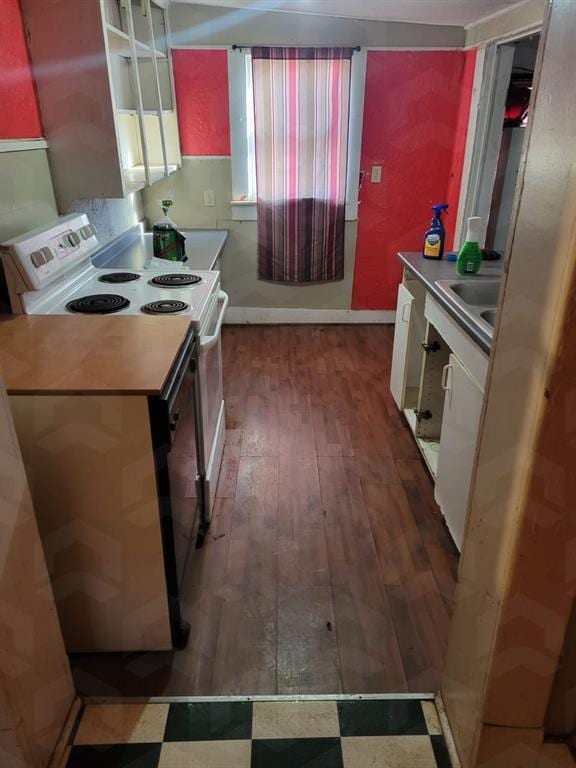 kitchen featuring white electric stove, sink, white cabinetry, and dark wood-type flooring