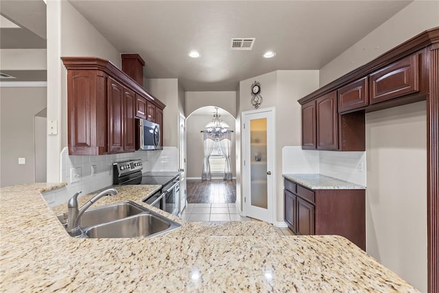 kitchen featuring sink, a notable chandelier, backsplash, appliances with stainless steel finishes, and light wood-type flooring