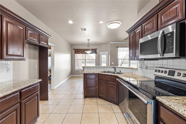 kitchen featuring pendant lighting, sink, decorative backsplash, light tile patterned floors, and stainless steel appliances