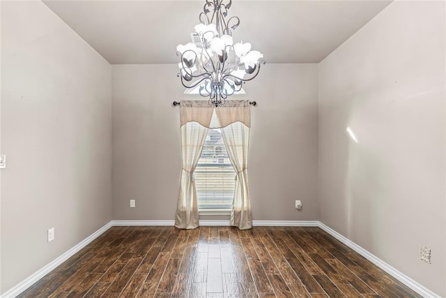 unfurnished room featuring dark hardwood / wood-style floors and an inviting chandelier