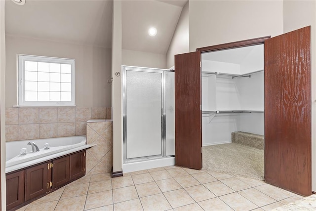 bathroom with tile patterned flooring, lofted ceiling, and independent shower and bath