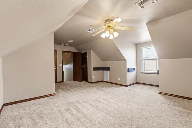 additional living space featuring light colored carpet, ceiling fan, and lofted ceiling