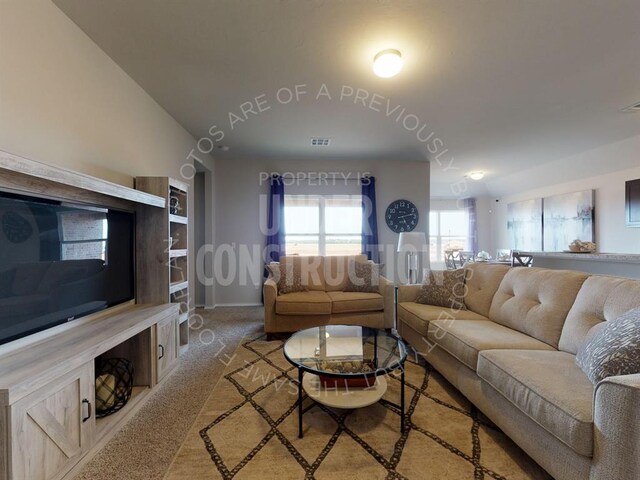 carpeted living room featuring vaulted ceiling