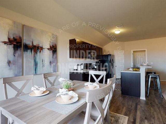 dining area with dark hardwood / wood-style flooring and vaulted ceiling