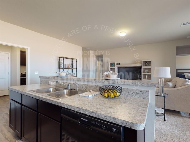 kitchen featuring a center island with sink, sink, black dishwasher, and light carpet