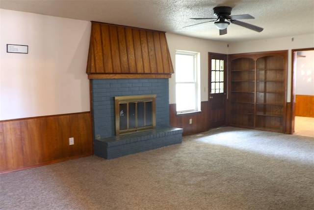 unfurnished living room featuring light colored carpet, ceiling fan, and wooden walls