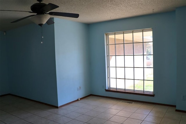 tiled empty room featuring ceiling fan, plenty of natural light, and a textured ceiling