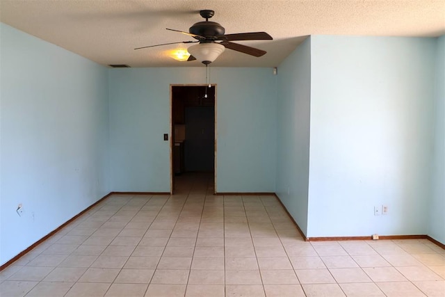 tiled empty room featuring ceiling fan and a textured ceiling