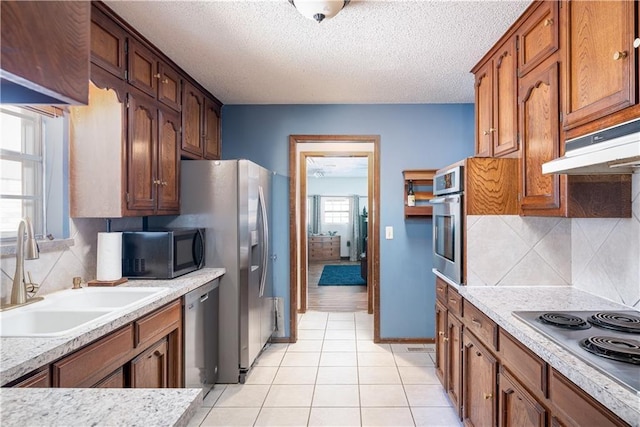 kitchen with decorative backsplash, sink, a textured ceiling, and appliances with stainless steel finishes