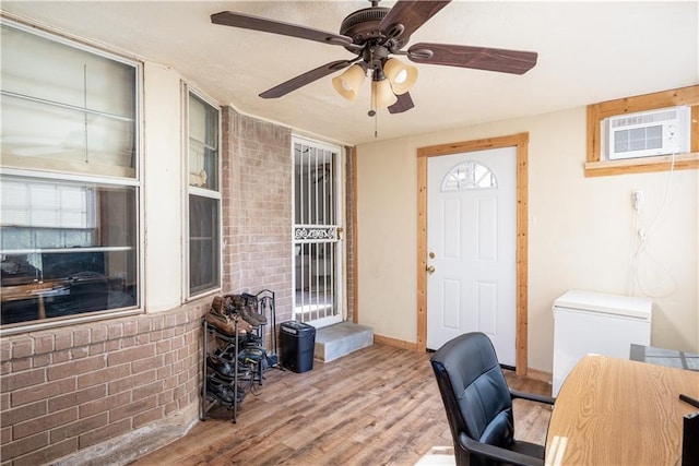 office with hardwood / wood-style flooring, ceiling fan, a wall mounted air conditioner, and a wealth of natural light