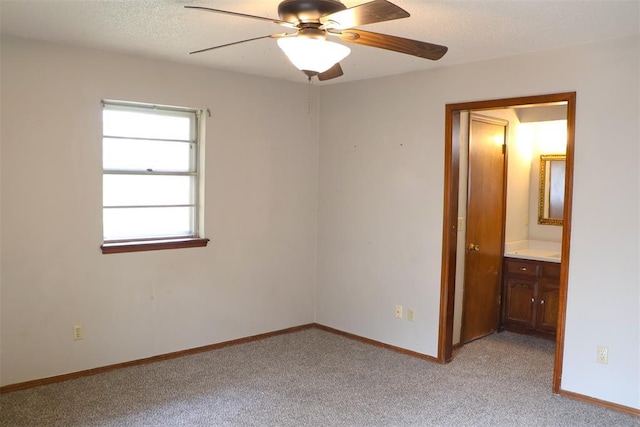 unfurnished room with a textured ceiling, ceiling fan, and light carpet