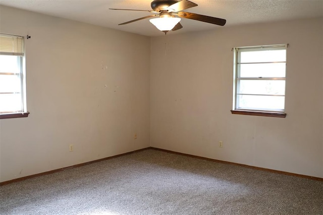 spare room featuring a textured ceiling, carpet floors, and ceiling fan